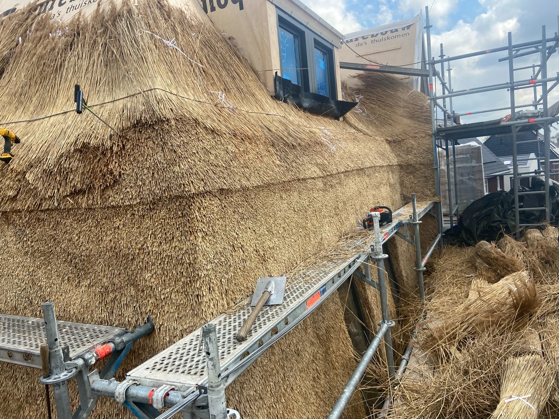 Rietdekker aan het werk aan een rieten dak in Overijssel